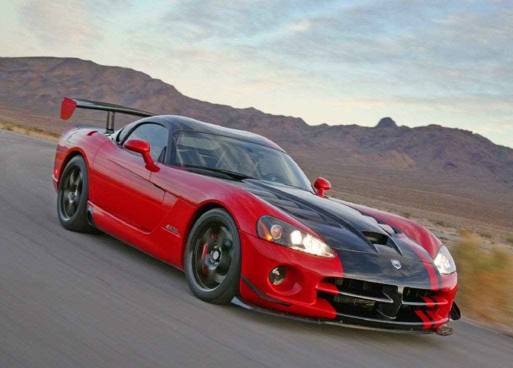 A red 2008 Dodge Viper with a thick black stripe posed in front of a mountain range