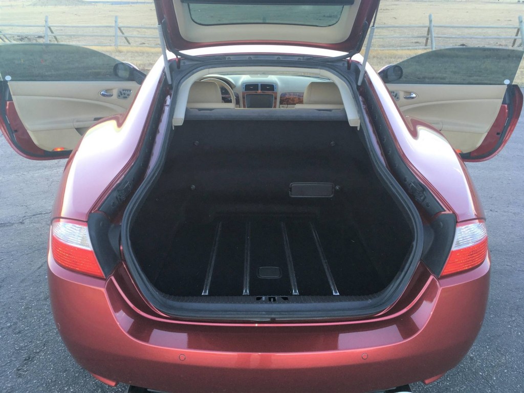 The rear view of a red 2008 Jaguar XK with its tailgate and doors open