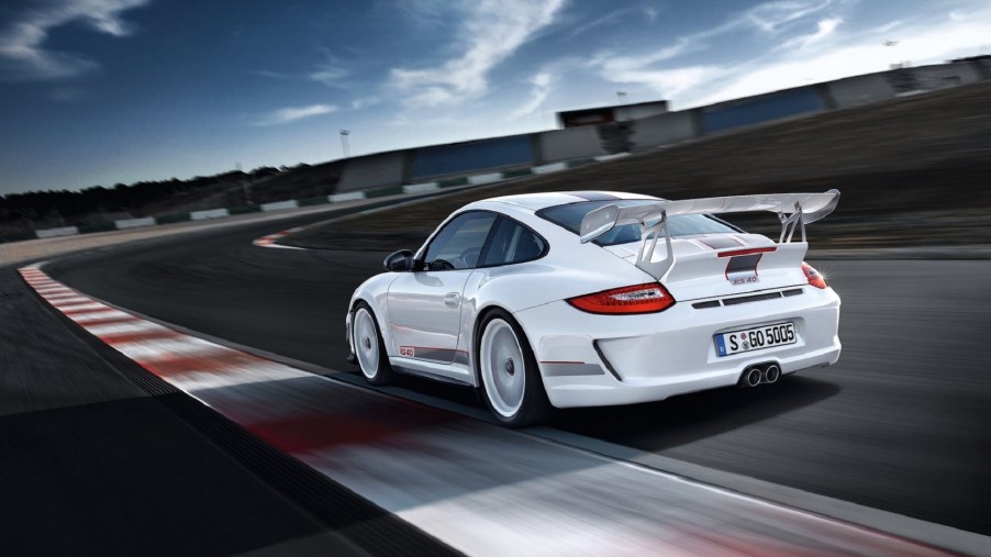 The rear 3/4 view of a white 2012 Porsche 911 GT3 RS 4.0 on a track