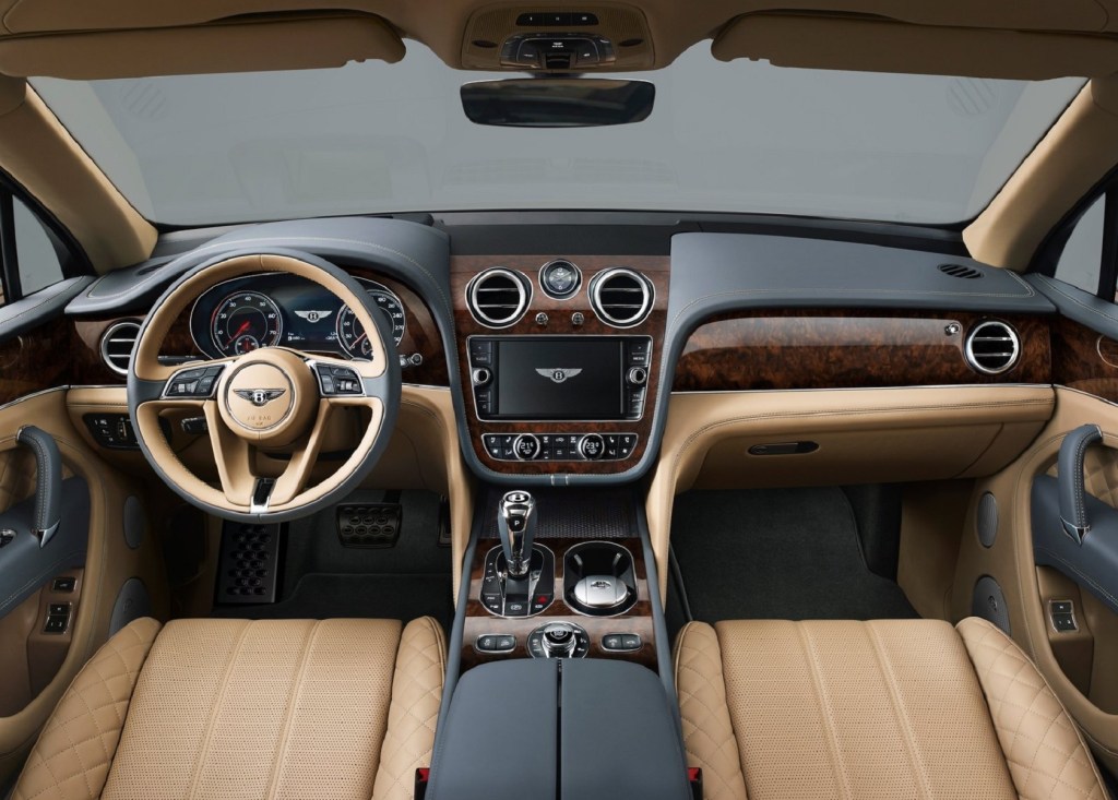The 2017 Bentley Bentayga's wood-trimmed black dash and tan-leather front seats