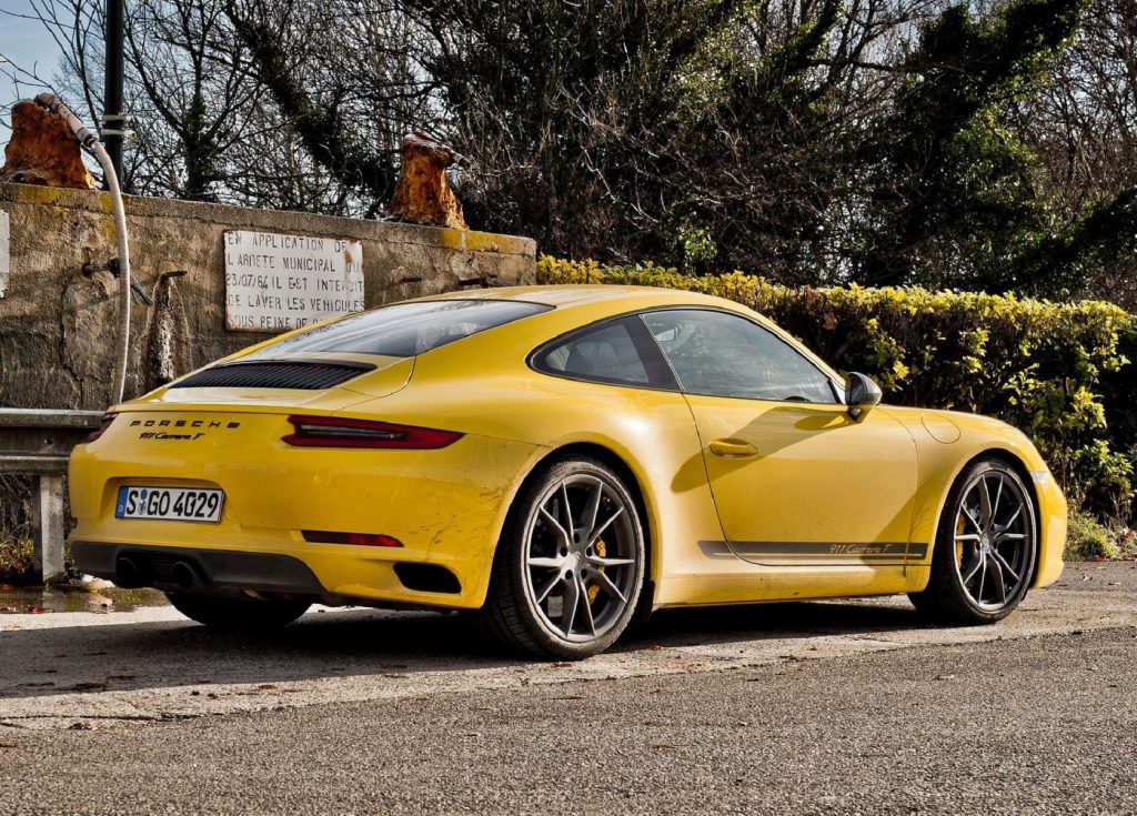 The rear 3/4 view of a yellow 2018 Porsche 911 Carrera T