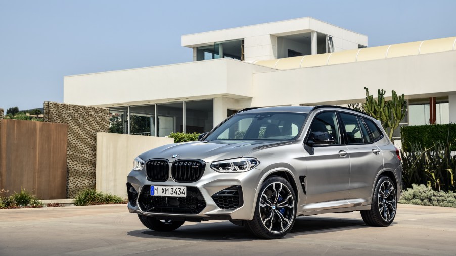 A silver 2019 BMW X3 sits outside a modern house