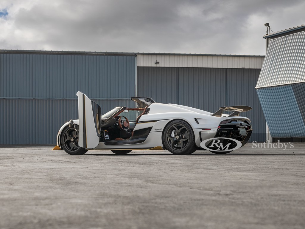 A white 2019 Koenigsigg Regara hypercar sits with its door open, and top off. 