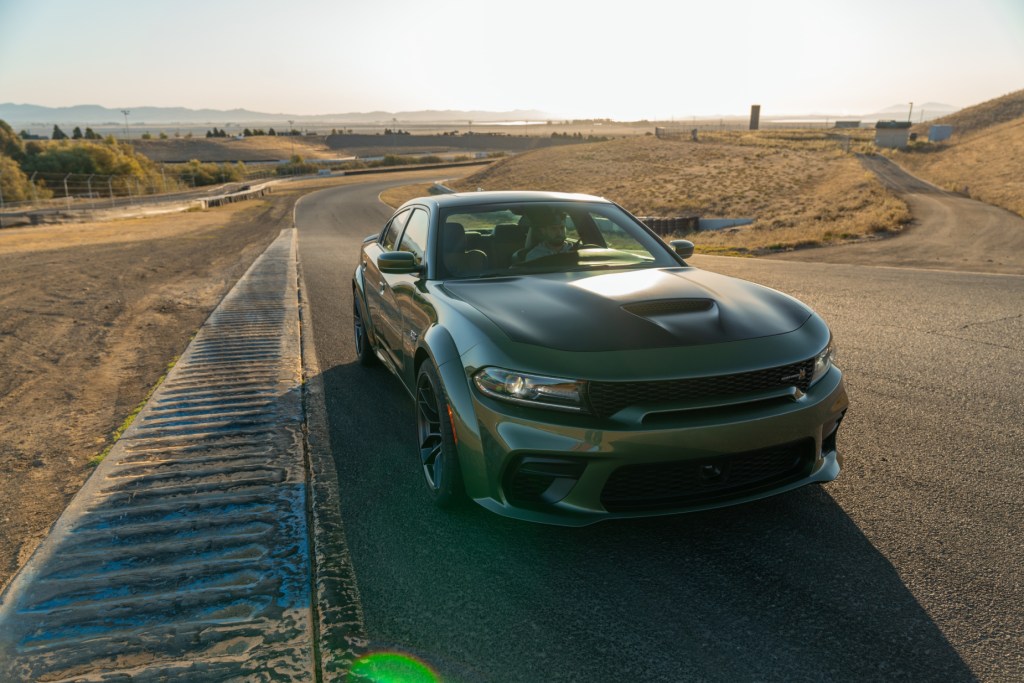 A green and black 2020 Dodge Charger driving down a road
