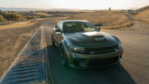 A green and black 2020 Dodge Charger driving down a road
