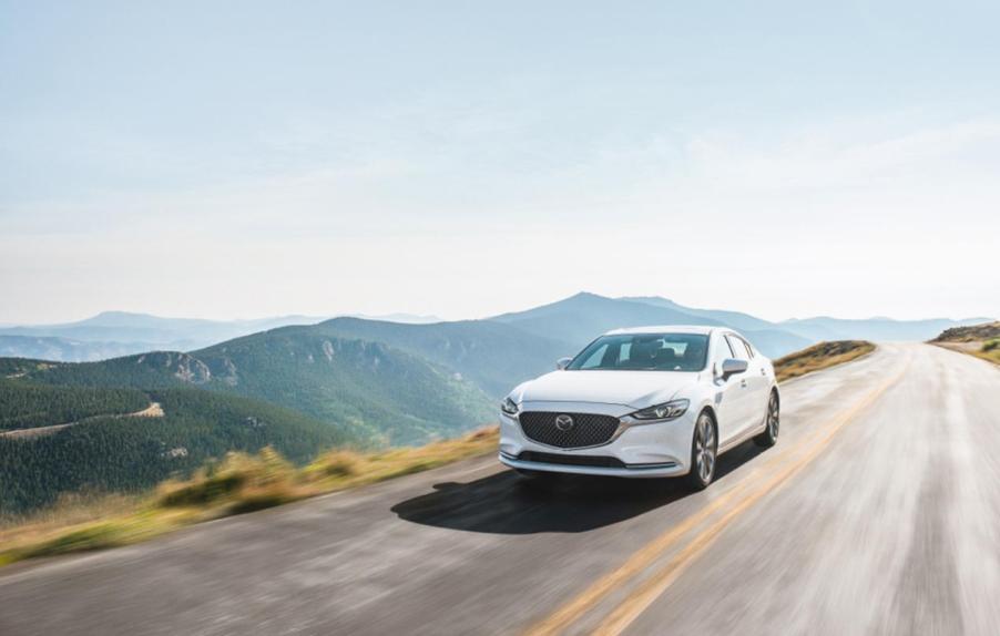 A white 2020 Mazda6 driving down a highway road