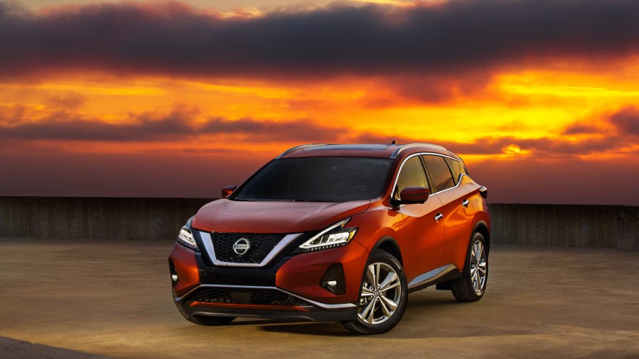 A red 2020 Nissan Murano parked on a rooftop with an orange sunset in the background