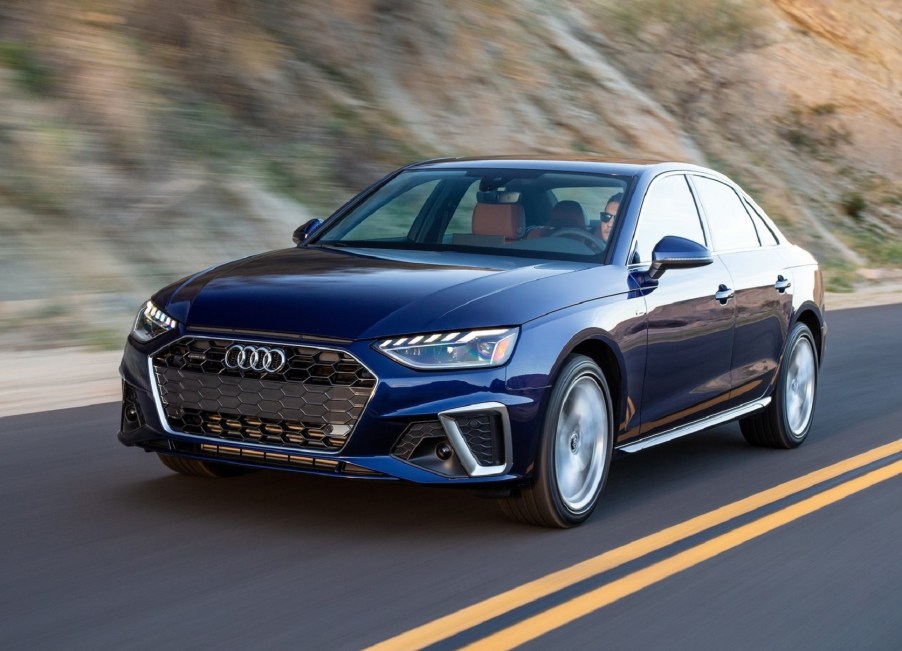 A blue 2021 Audi A4 drives on a road