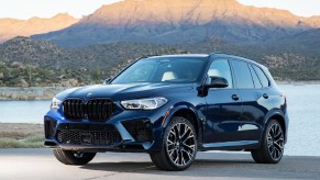 A blue 2021 BMW X5 M Competition by a desert lake