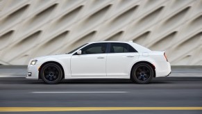 A white 2021 Chrysler 300 on display next to a fancy white wall