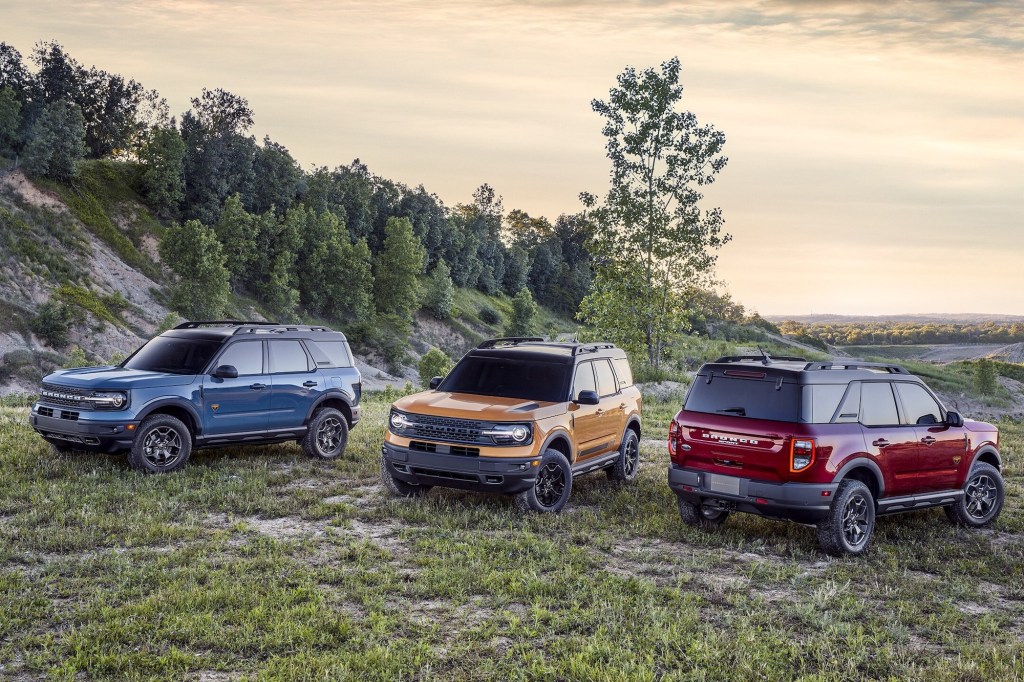 2021 Ford Bronco models in blue, yellow, and red sit on a hillside