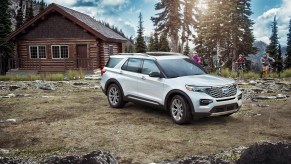 A white 2021 Ford Explorer parked on display in front of a country house.