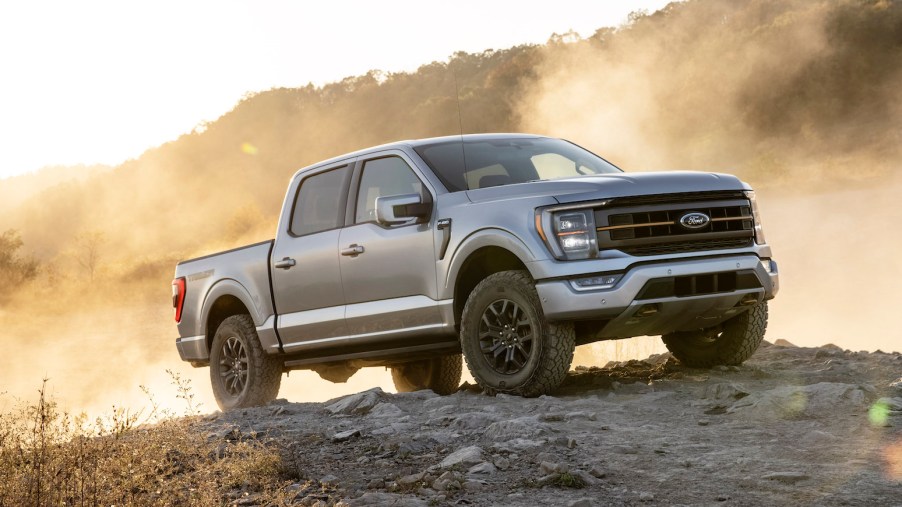 A silver 2021 Ford F-150 Tremor stands atop a dusty hill