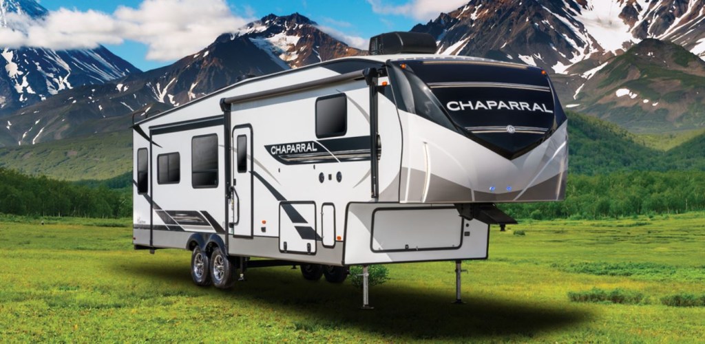 A 2021 Forest River Chaparral Fifth-Wheel RV Trailer sits at the base of a mountainside.