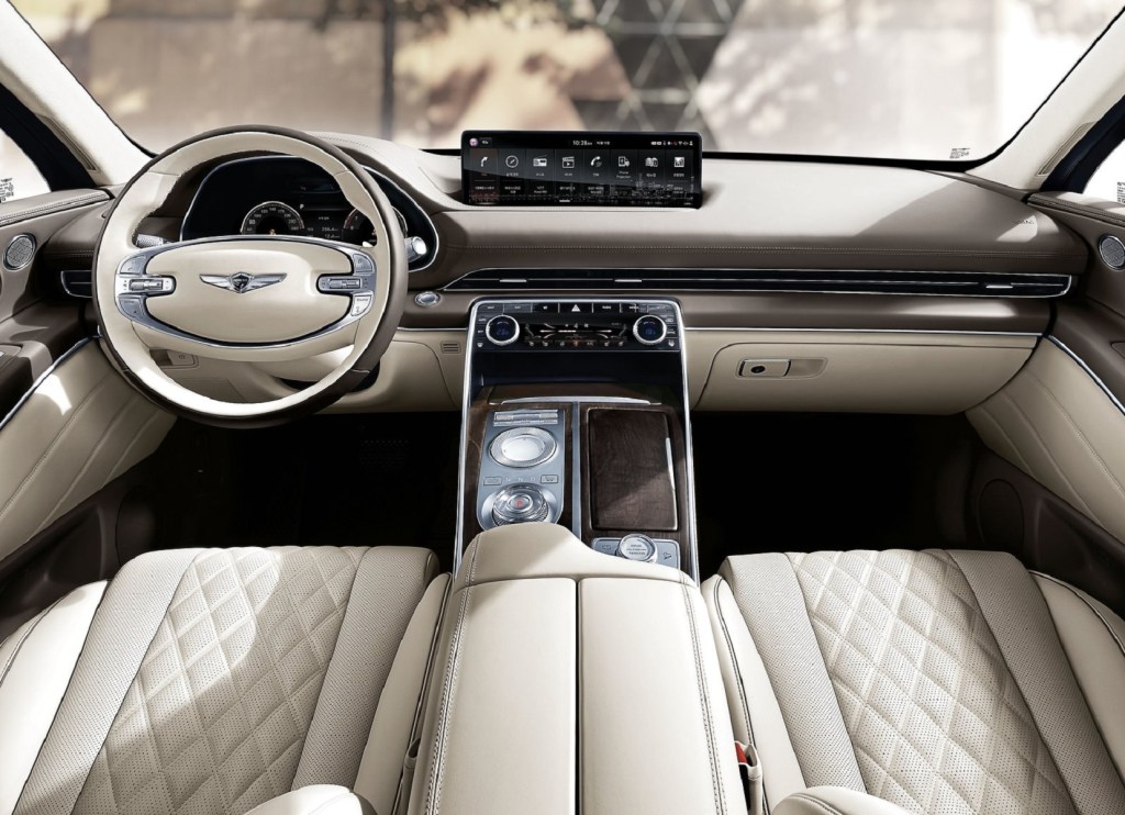 The 2021 Genesis GV80's white-leather front seats and wood-trimmed brown dashboard