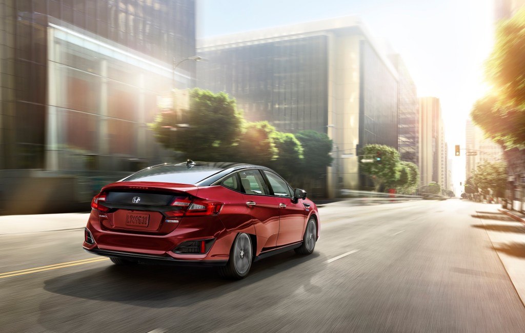 A red 2020 Honda Clarity drives down a city street