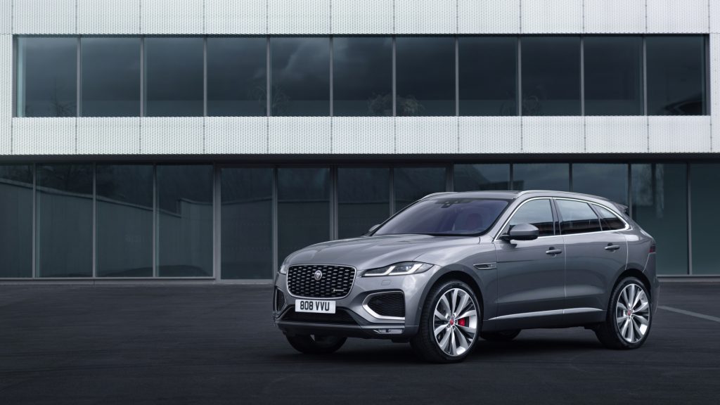 A silver 2021 Jaguar F-Pace parked on display in front of a building