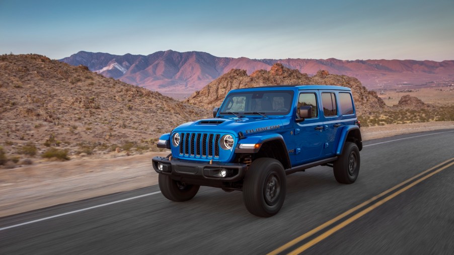 2021 Jeep Wrangler driving with a mountain range in the background