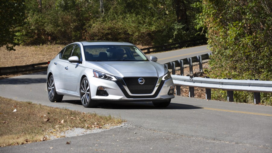 A silver 2021 Nissan Altima driving down a winding road