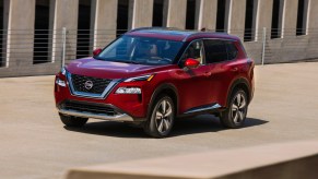 A red 2021 Nissan Rogue driving down a road