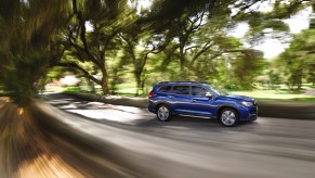 A blue 2021 Subaru Ascent driving down a road