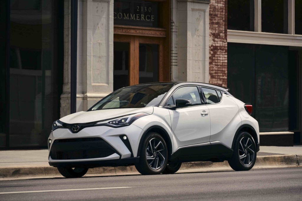 A white 2021 Toyota C-HR driving down a city road