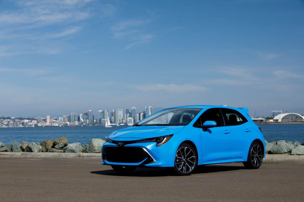 A blue 2021 Toyota Corolla Hatchback on display next to the water