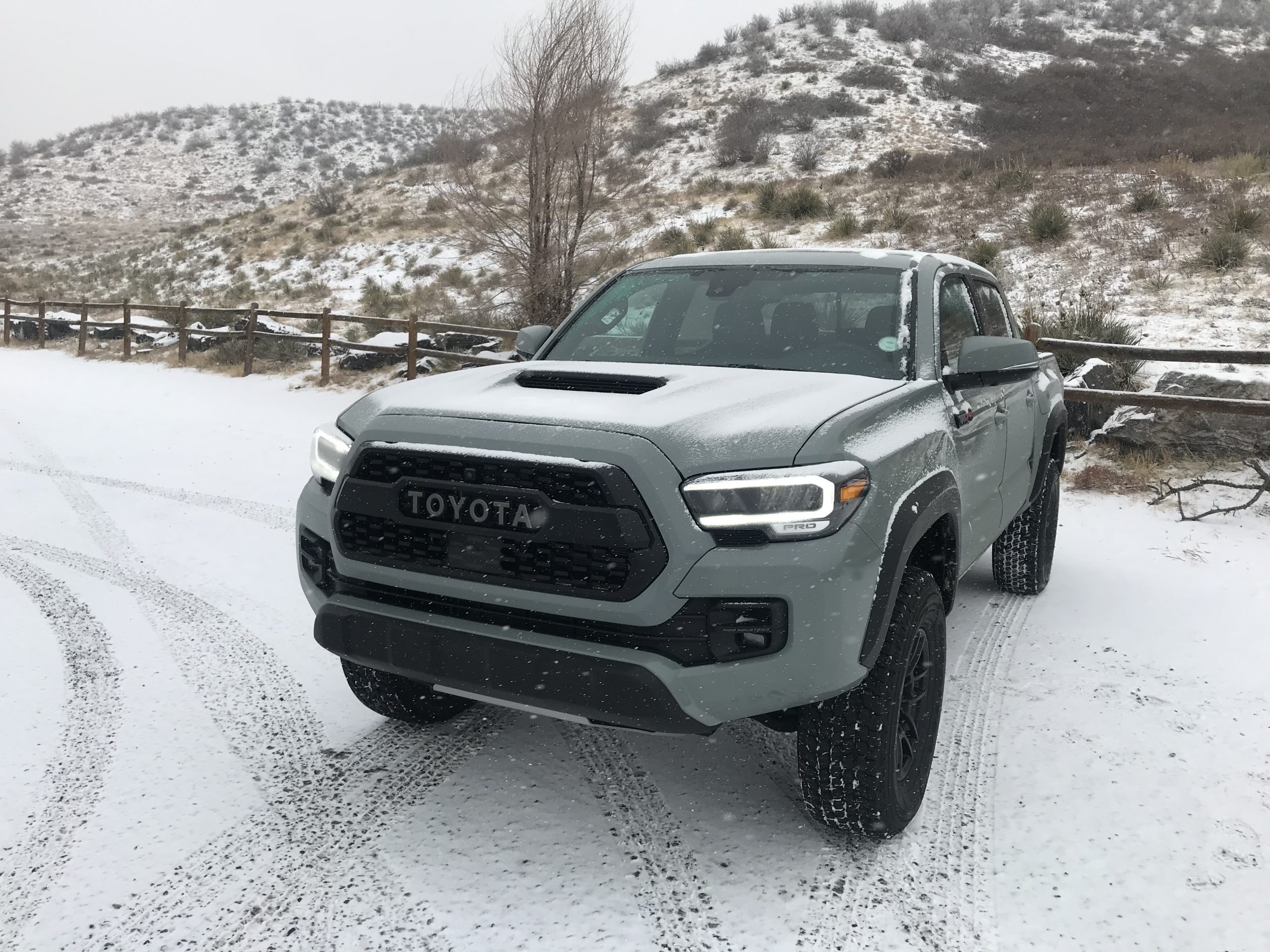 a 2021 toyota tacoma trd pro in the snow with the lunar rock paint color