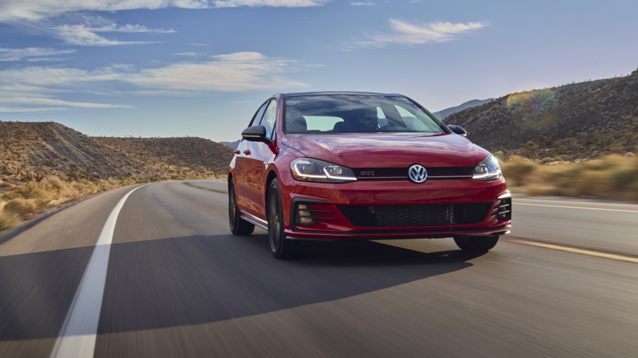 A red 2021 Volkswagen Golf GTI driving down a highway