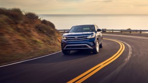 A blue 2021 Volkswagen Atlas driving down a highway road