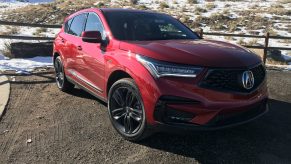 A red Acura RDX parked curbside.