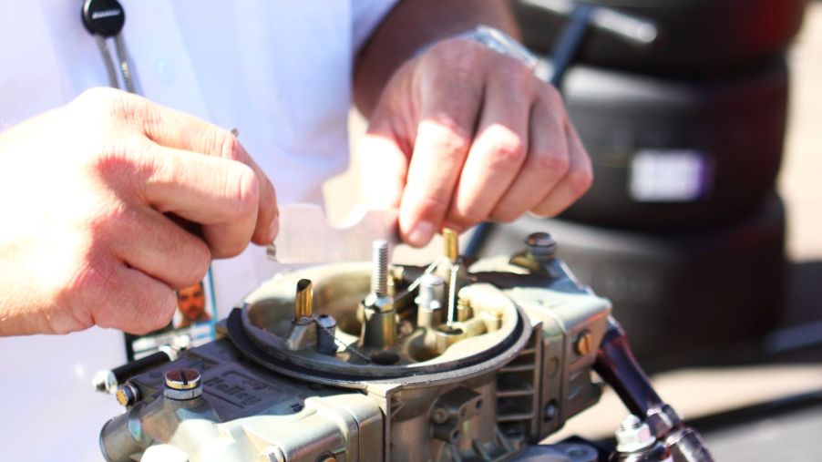 A race official inspects a NASCAR carburetor