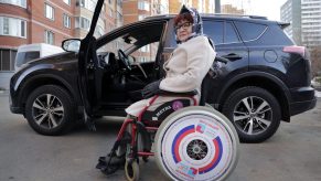 Working pensioner Olga Abukova, 62, in a wheelchair near her car