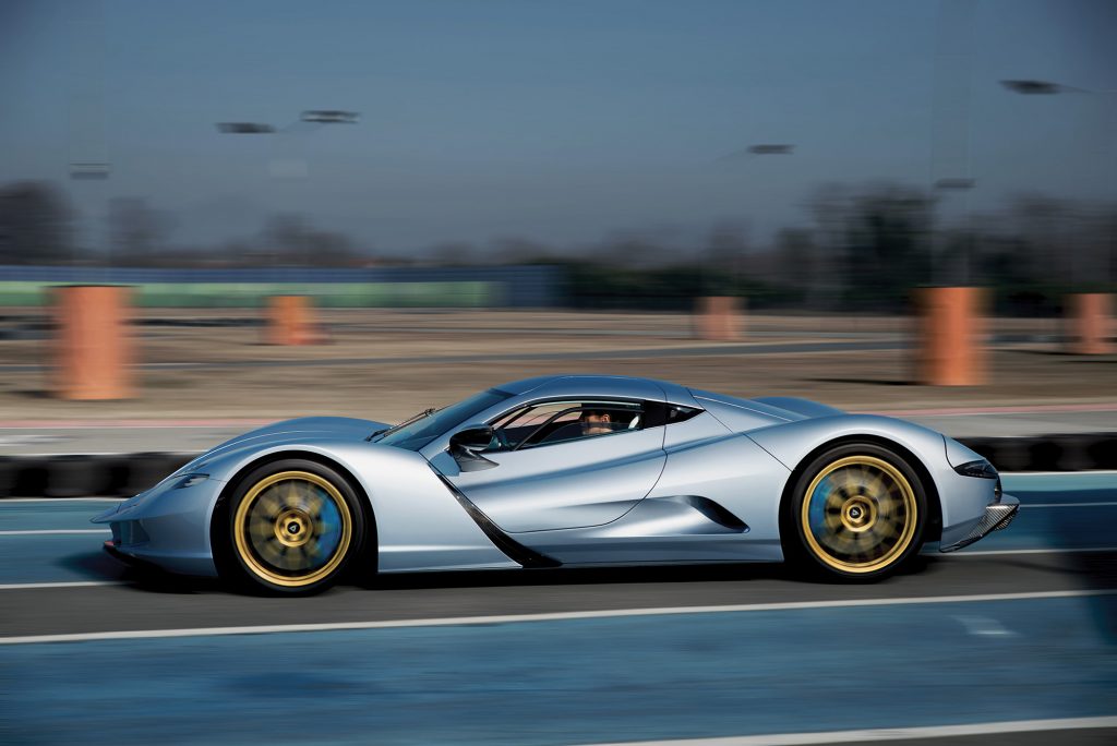 A driver's side profile view of the Aspark Owl in silver on the track. 