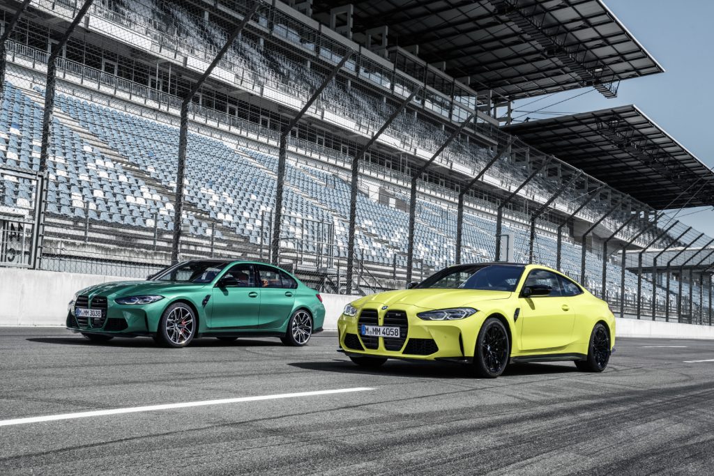 Green and yellow BMW M3 Competition models driving on a track