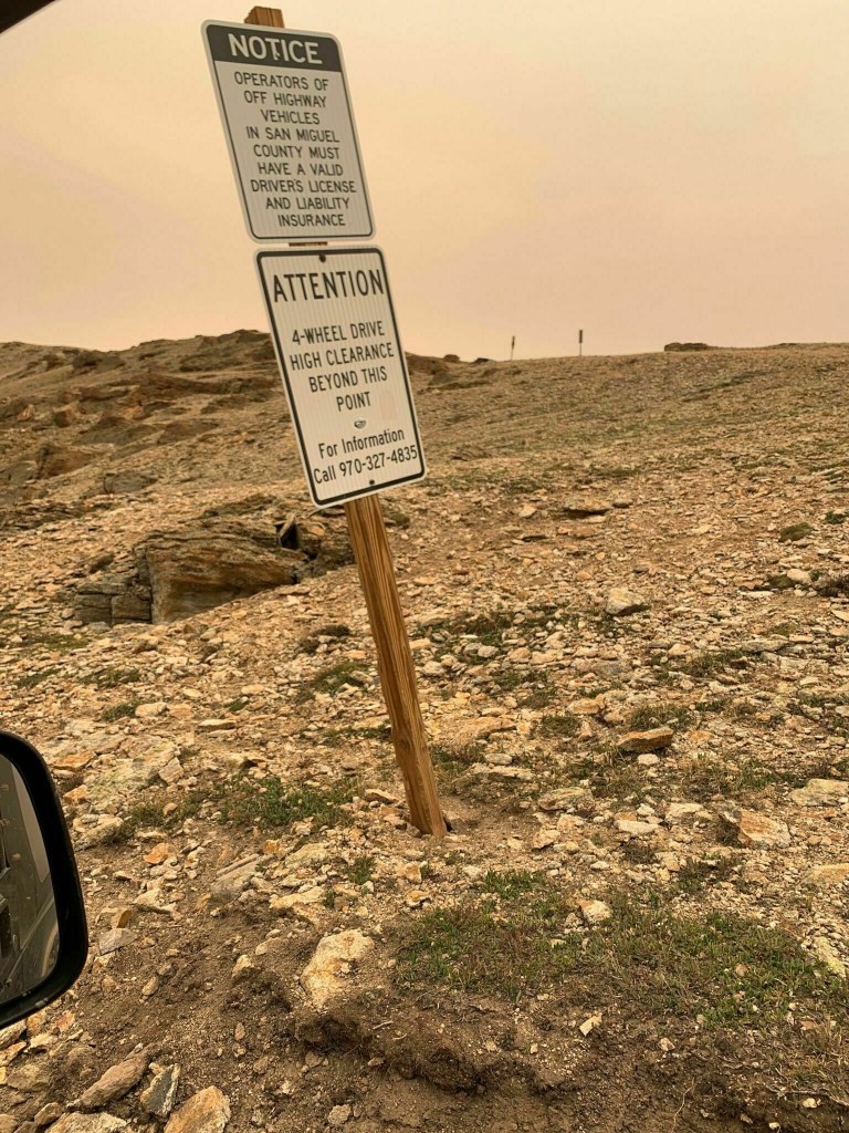 a warning sign before the steps and switchback of Black Bear Pass 