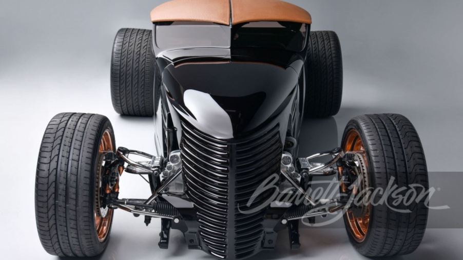 Head-on view of a black custom rat rod sits on copper finished, one-off wheels.