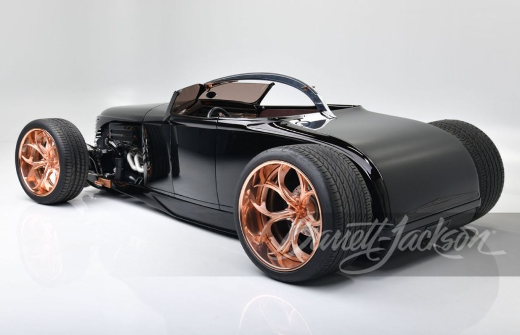 The rear of a black custom rat rod sits on copper finished, one-off wheels.