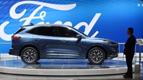 A staff member stands beside a Ford Escape Titanium at the Shanghai Auto Show