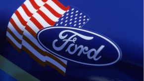 A Ford logo seen next to an American flag