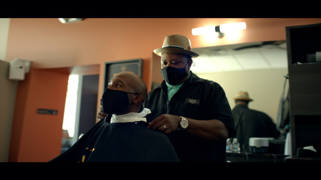 Two men wearing masks at the barber