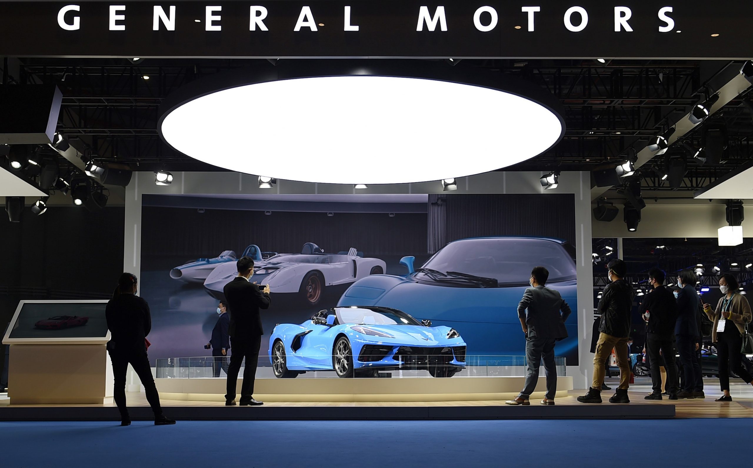 Visitors are attracted by a Chevrolet Corvette Stingray at the booth of General Motors at the Automobile exhibition area