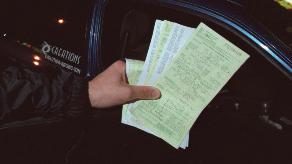 An image of a few speeding tickets held up for the camera to see.