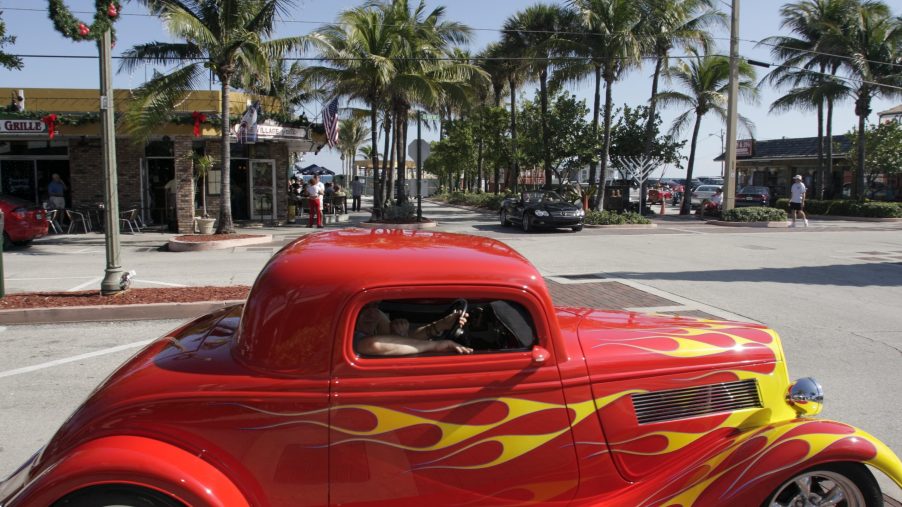 A red hot rod with yellow flames painted on.