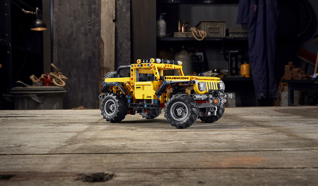 A toy model of a Jeep Wrangler, made with yellow and black LEGO bricks
