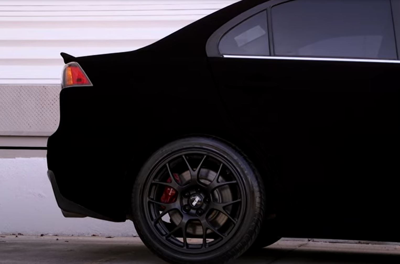 The rear of a Mitsubishi Evo painted in Musou Black