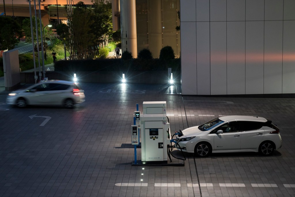 A Nissan Motor Co. Leaf electric vehicle is charged at the company's headquarters at night on May 27, 2020 in Yokohama, Japan