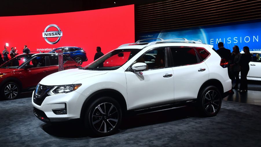 A white Nissan Rogue on display at an auto show
