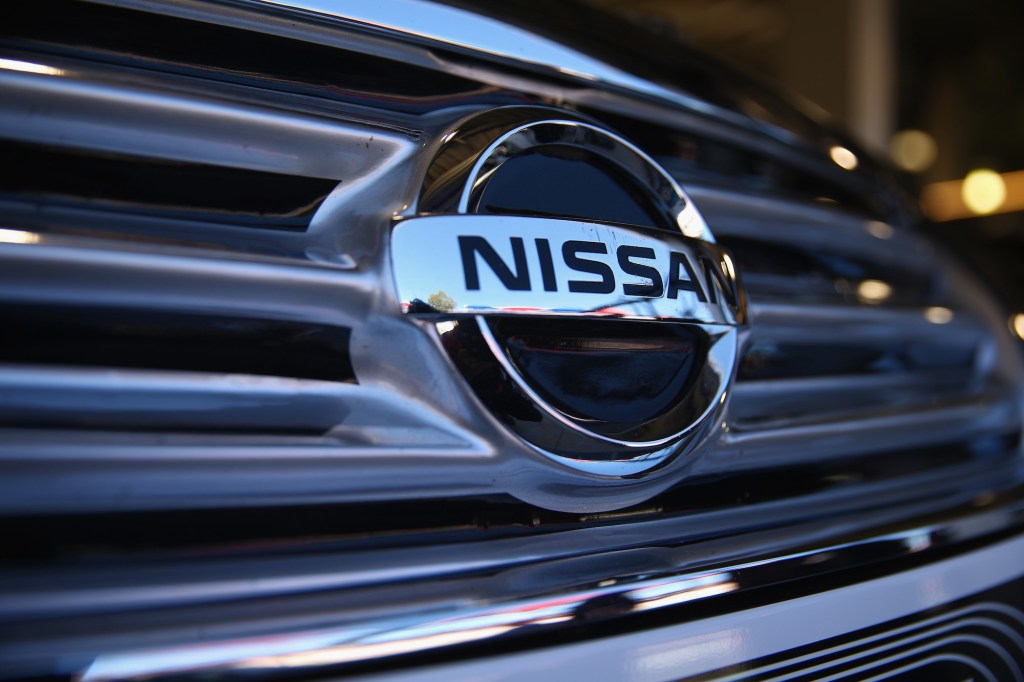 A silver Nissan logo as seen on the silver grille of a vehicle