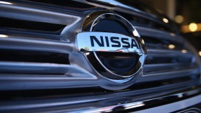 A silver Nissan logo as seen on the silver grille of a vehicle